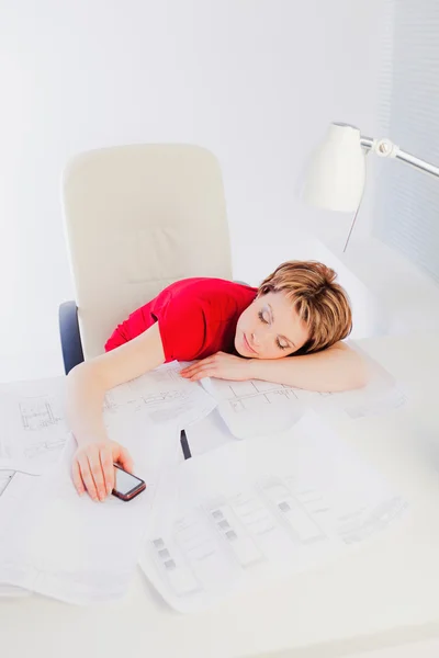Junge Frau schläft auf Schreibtisch mit Dokumenten — Stockfoto