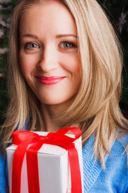 hediye kutusu ile gülümseyen kadın