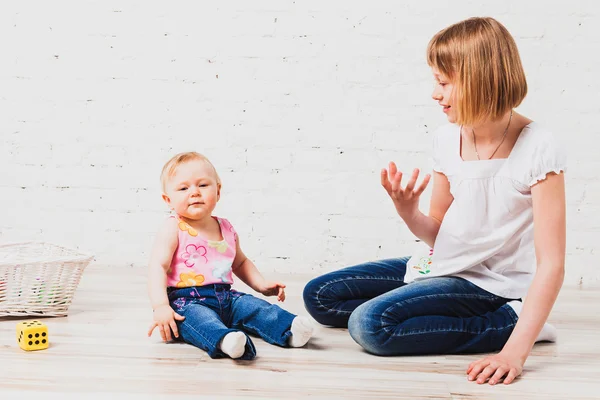 Two sisters sitting on floor — Stock Photo, Image