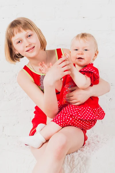 漂亮的女孩在膝盖上抱着她的小妹妹 — 图库照片