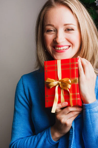 Laughing woman holding red gift — Stock Photo, Image