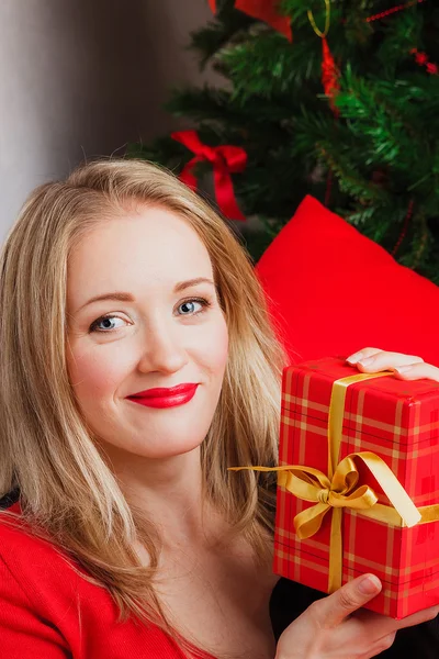 Smiling woman holds red gift — Stock Photo, Image