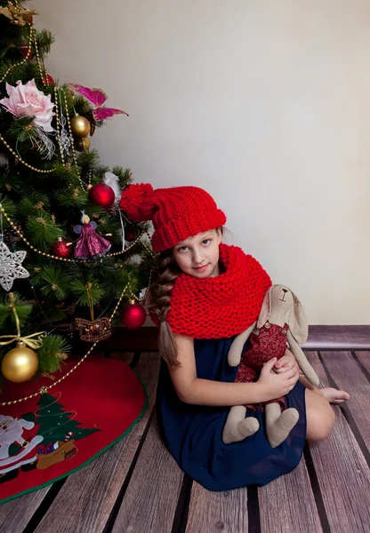 Niña sentada junto al árbol de Navidad — Foto de Stock