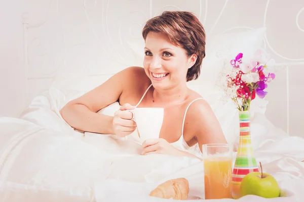 Senhora feliz tomando café da manhã na cama — Fotografia de Stock