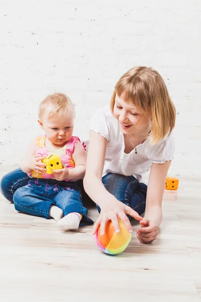 Söt baby leker med hennes syster — Stockfoto