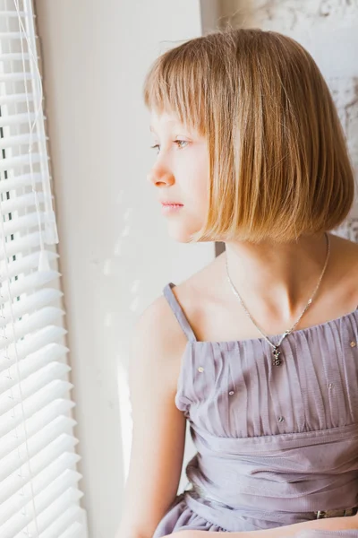 Menina bonito olhando para a janela — Fotografia de Stock