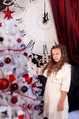 Noel ağacı süsleyen küçük kız