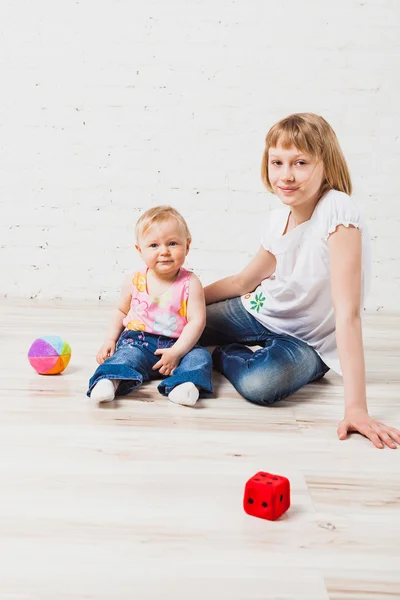 Jolie fille assise avec sa petite sœur — Photo