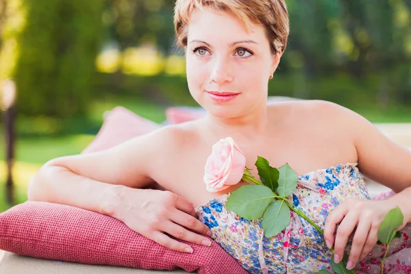 Mulher agradável com rosa na mão — Fotografia de Stock