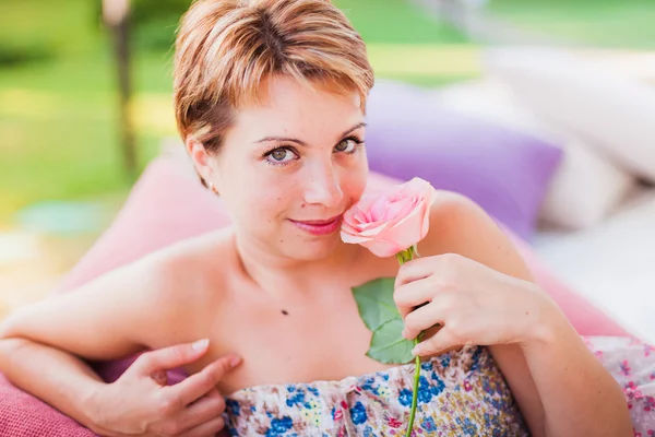 Niedliche kurzhaarige Frau mit rosa Rose — Stockfoto