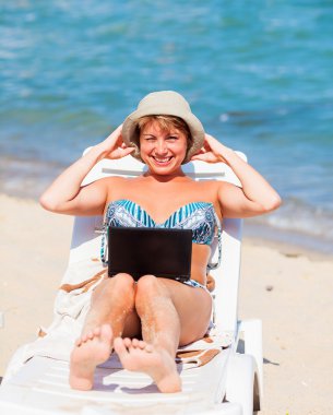 Gülümseyen şezlong üzerinde oturan kadın