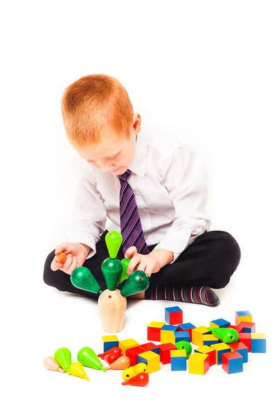 Мальчик играет с деревянными игрушками — стоковое фото