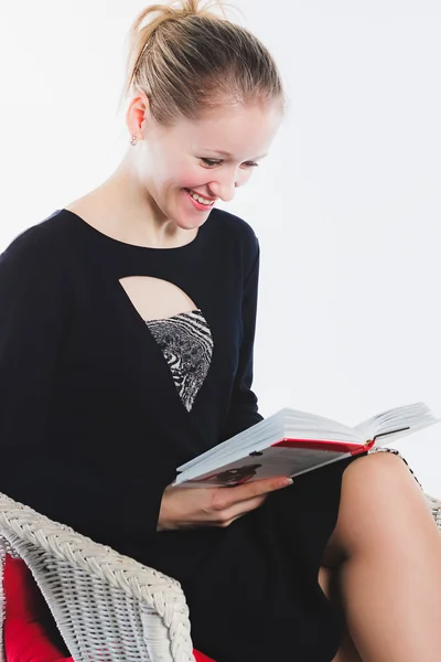 Jovem mulher lê livro engraçado — Fotografia de Stock