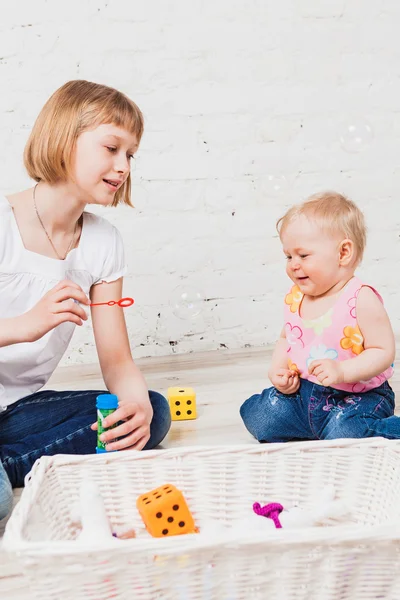 Zwei glückliche Mädchen, die mit Blasen spielen — Stockfoto