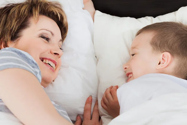 Mutter und ihr Sohn liegen im Bett — Stockfoto