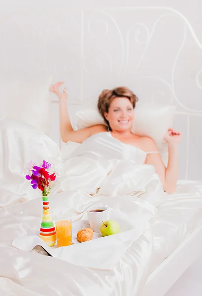 Donna felice con colazione sul suo letto — Foto Stock