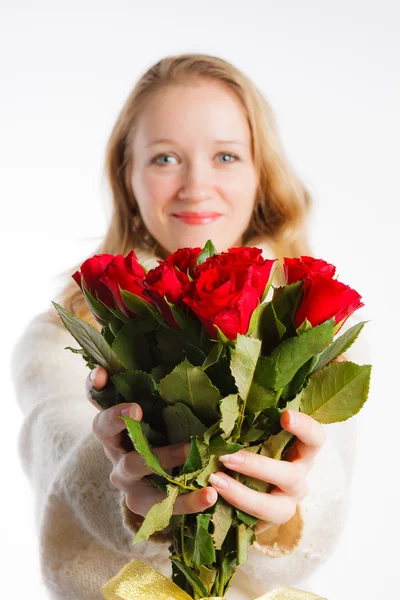 Beautiful woman holding out  red roses, focus on roses — Stock Photo, Image