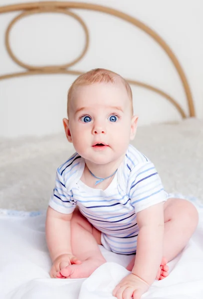 Cute baby boy sitting on bed Stock Image