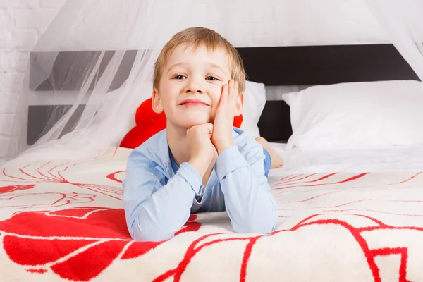 かわいい男の子がベッドの上に敷設 — ストック写真