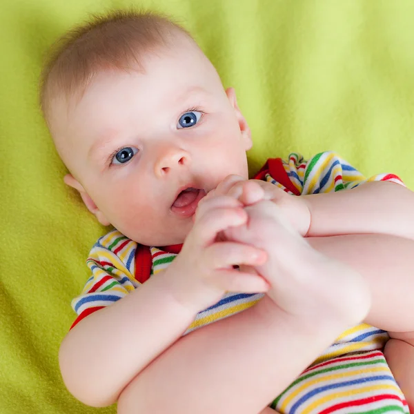 Little boy holding his feet — Stock Photo, Image