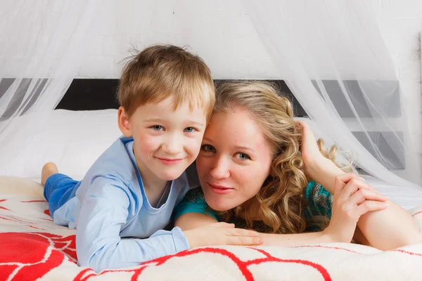 Happy woman with her child laying on belly — Stock Photo, Image