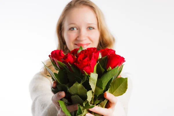 Усміхнена жінка з червоними трояндами, фокус на трояндах — стокове фото