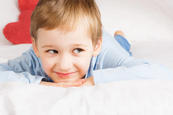 Netter kleiner Junge liegt auf dem Bett — Stockfoto