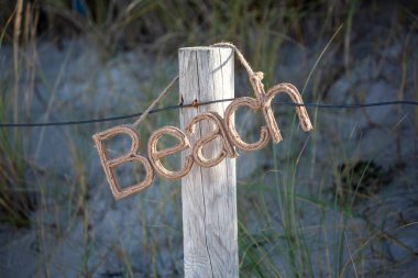 rustic beach sign created with rope at the dunes of a baltic sea beach, perfect for a postcard, gift bag or travel project