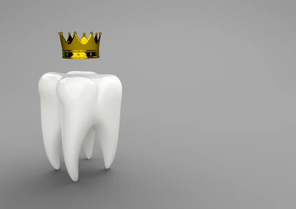 Белый зуб с золотой короной — стоковое фото