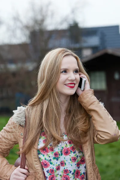 Mujer rubia joven hablando en el teléfono celular al aire libre — Foto de Stock