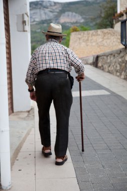 Yaşlı kamışı ile koridor üzerinde yürüyen adam