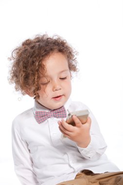 Adorable Curly Young Kid Looking at Mobile Phone clipart