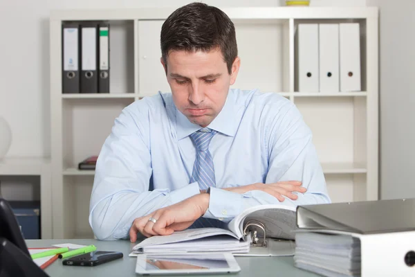 Handsome businessman reviewing report papers — Stock Photo, Image