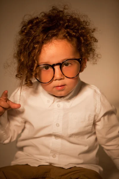 Schattige krullend jongen met bril kijken Camera — Stockfoto