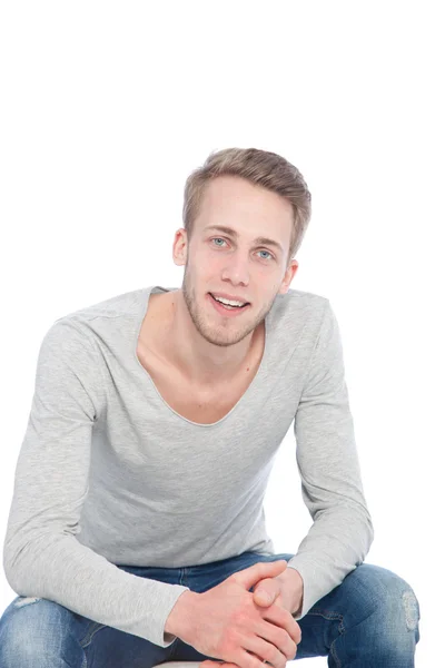 Sympathisch lächelnder junger Mann auf einem Stuhl — Stockfoto