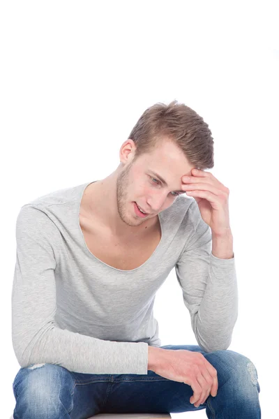 Doordachte knappe jongen zittend op een stoeltje — Stockfoto