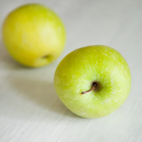 Groene appels op witte houten achtergrond — Stockfoto