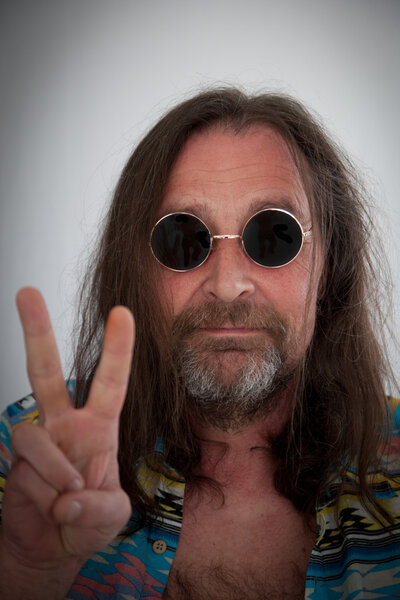 male hippie with long shoulder length hair making a peace sign with his fingers