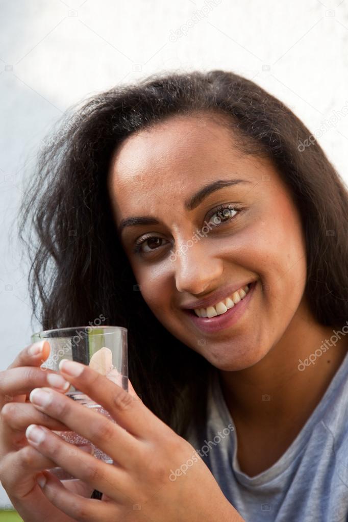 Smiling Young Woman Holding a Glass of Water