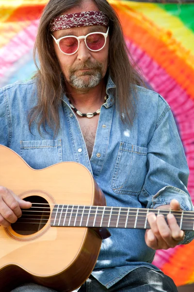 Бородатый хиппи средних лет играет на гитаре — стоковое фото