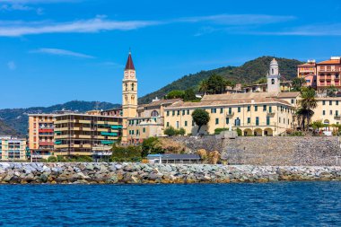 Liguria, İtalya 'da küçük bir kasaba olan Recco' da mavi gökyüzünün altındaki evler ve çan kulesine deniz manzarası.