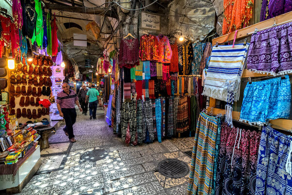 JERUSALEM, ISRAEL - JULY 16, 2018: Colorful traditional clothes for sale at the famous bazaar in old city of Jerusalem - popular place and tourist destination.