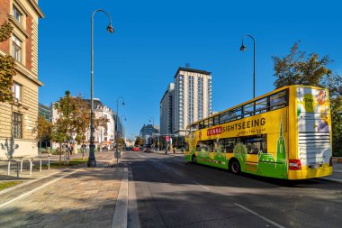 VİYANA, AUSTRIA - SEPTEMBER 28, 2018: Viyana caddesinde mavi gökyüzü altında turistik tur otobüsü - Avusturalya başkenti, ünlü ve popüler turizm merkezi.