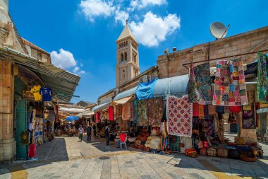 JERUSALEM, ISRAEL - 16 Temmuz 2018: Muristan 'da geleneksel hediyelik eşya ve halı dükkanları ile dar bir cadde manzarası - Eski Kudüs' ün Hristiyan mahallesi, turistler ve hacılar arasında popüler bir yer.