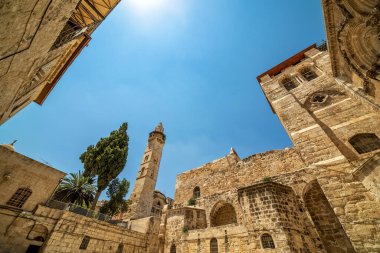 İsrail 'in Kudüs şehrinde, mavi gökyüzünün altında, Kutsal Mezar Kilisesi ve minarenin dış görünüşü.