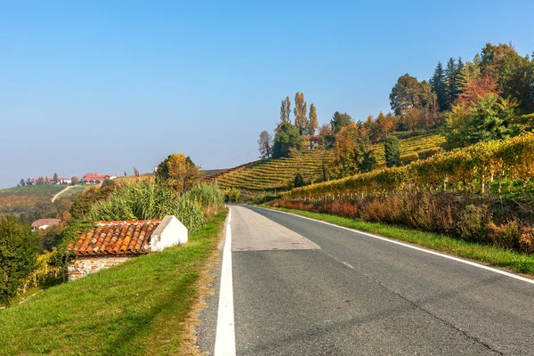 Landelijke weg en herfst heuvels in Piemonte, Italië. — Stockfoto