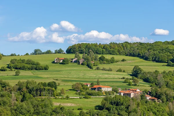 Casas rurales en pastos verdes en Piamonte, Italia . — Foto de Stock