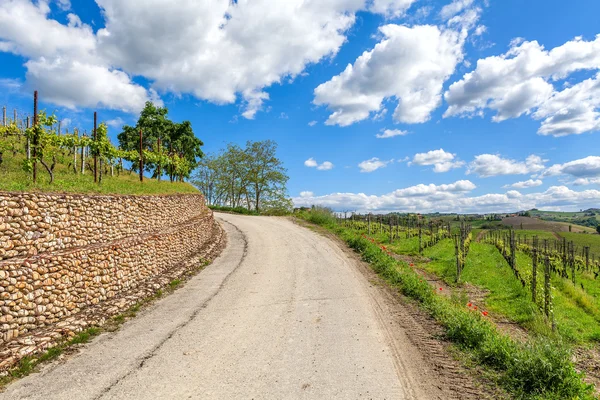 Carretera rural bajo el cielo azul en Piamonte, Italia . — Foto de Stock