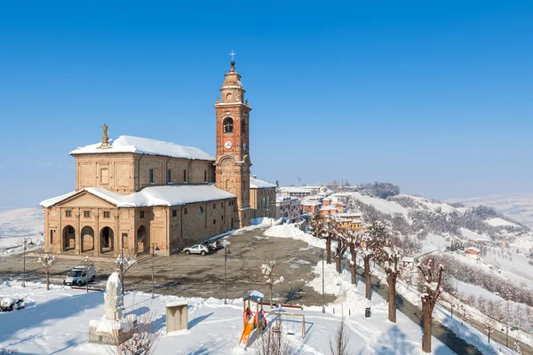 Chiesa parrocchiale e colline innevate in Italia . — Foto Stock