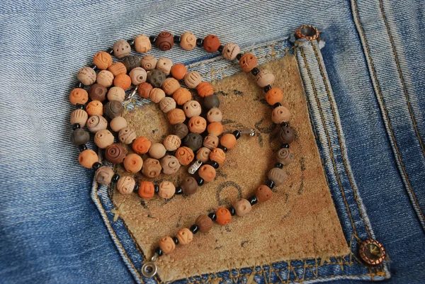 Ceramic beads on old jeans — Stock Photo, Image